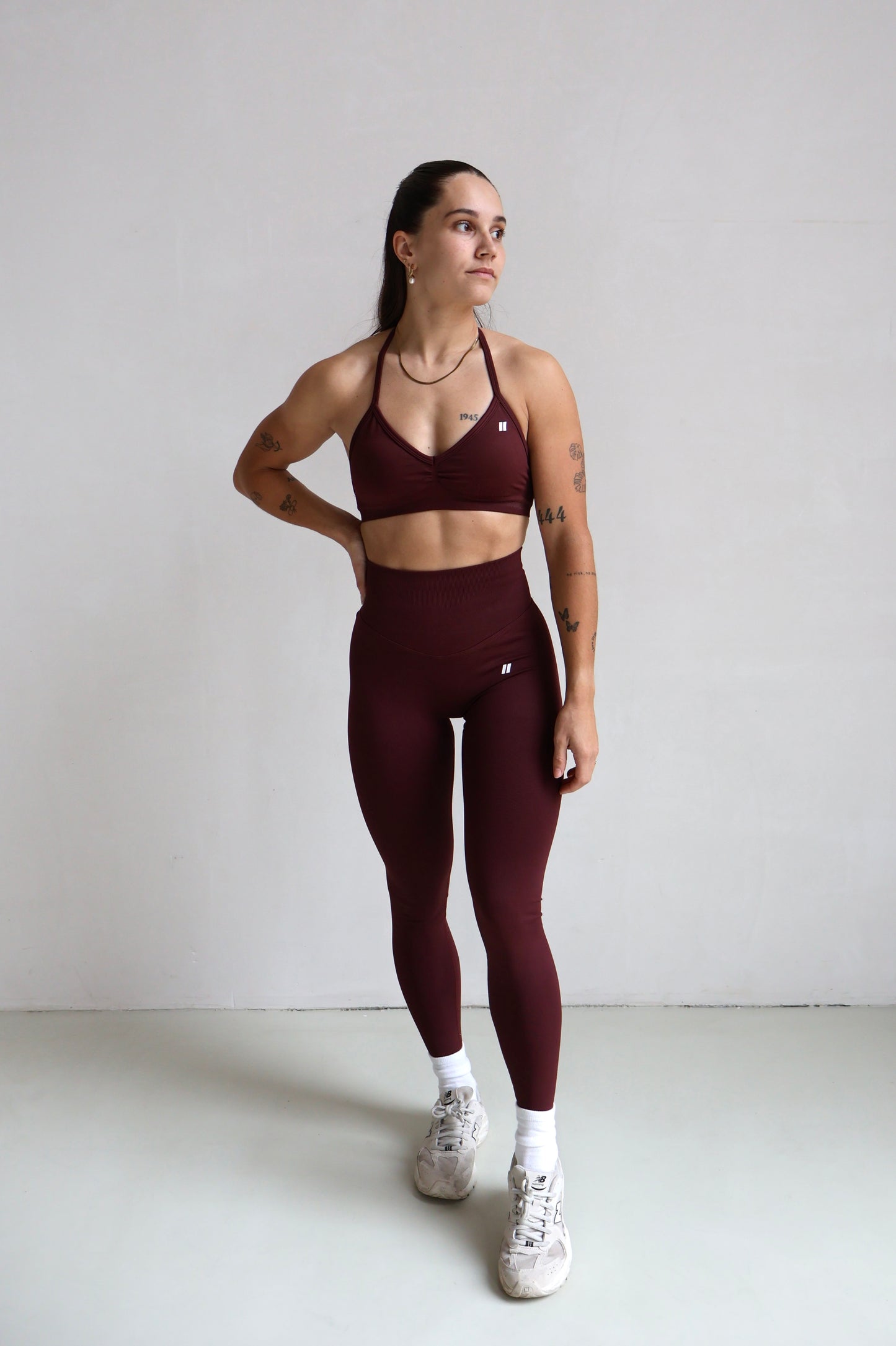 Een donkerrode sportkleding set met een sportbh en een matching legging